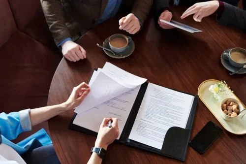 top-view-unrecognizable-businesswoman-signing-contract-after-negotiation-with-business-partners-cafe_274679-11015